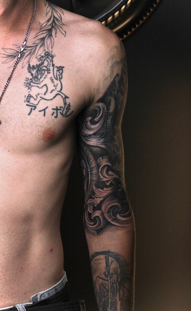 Ornamental blackwork sleeve and chest tattoo under studio light