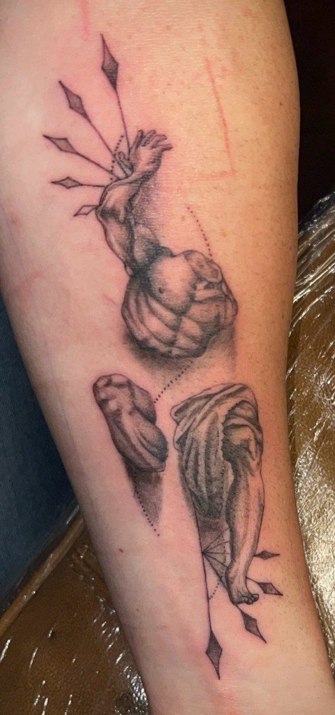 Fine-line tattoo of broken classical statue fragments arranged down a forearm with geometric guides